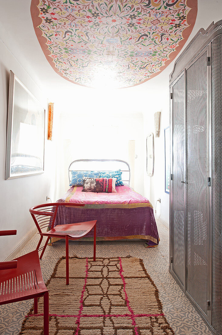 Ceiling mural and metal locker in light-flooded bedroom