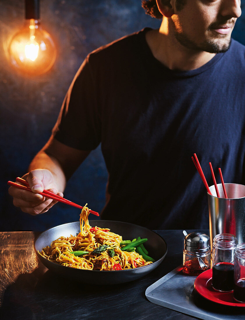 Man eating stir-fried spicy noodles