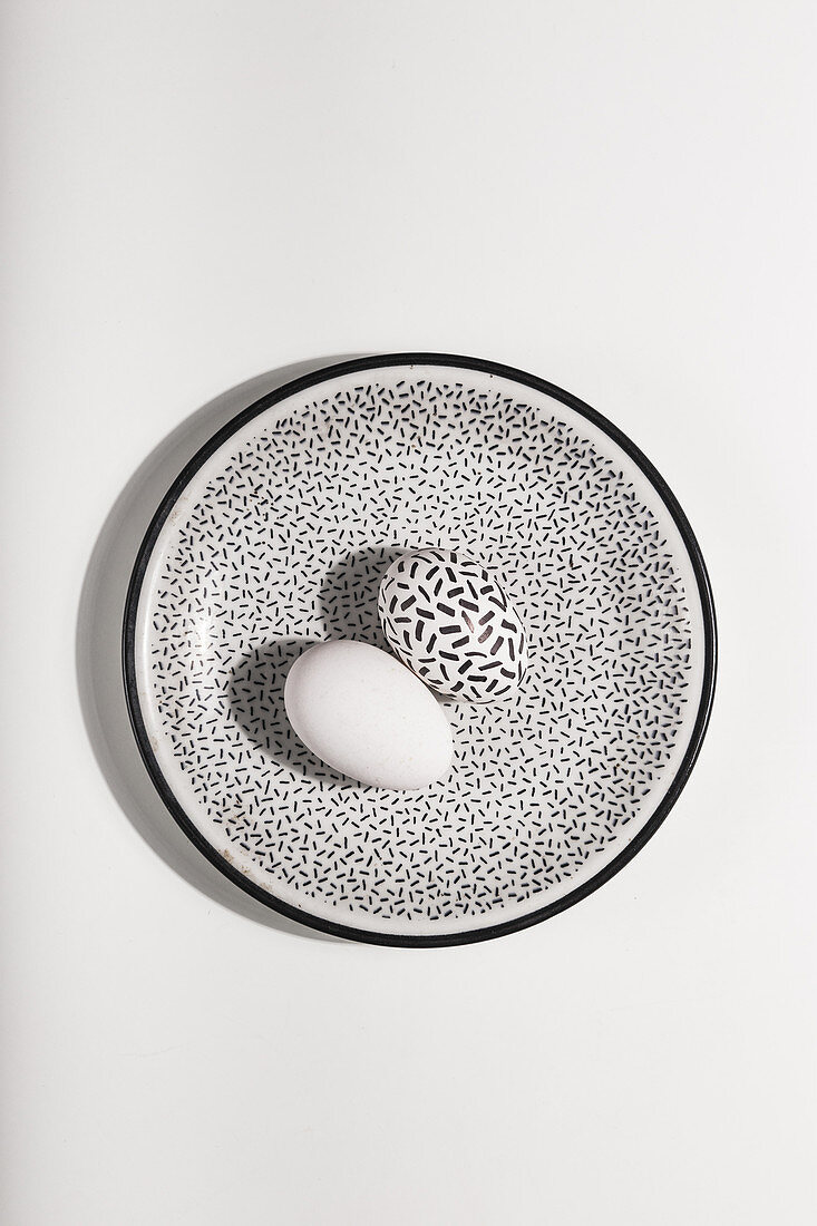 Black and white Easter eggs on a speckled plate
