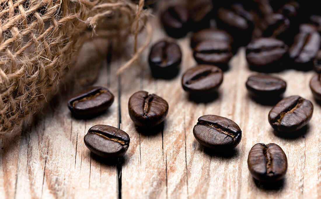 Roasted coffee beans on a wooden surface (close-up)