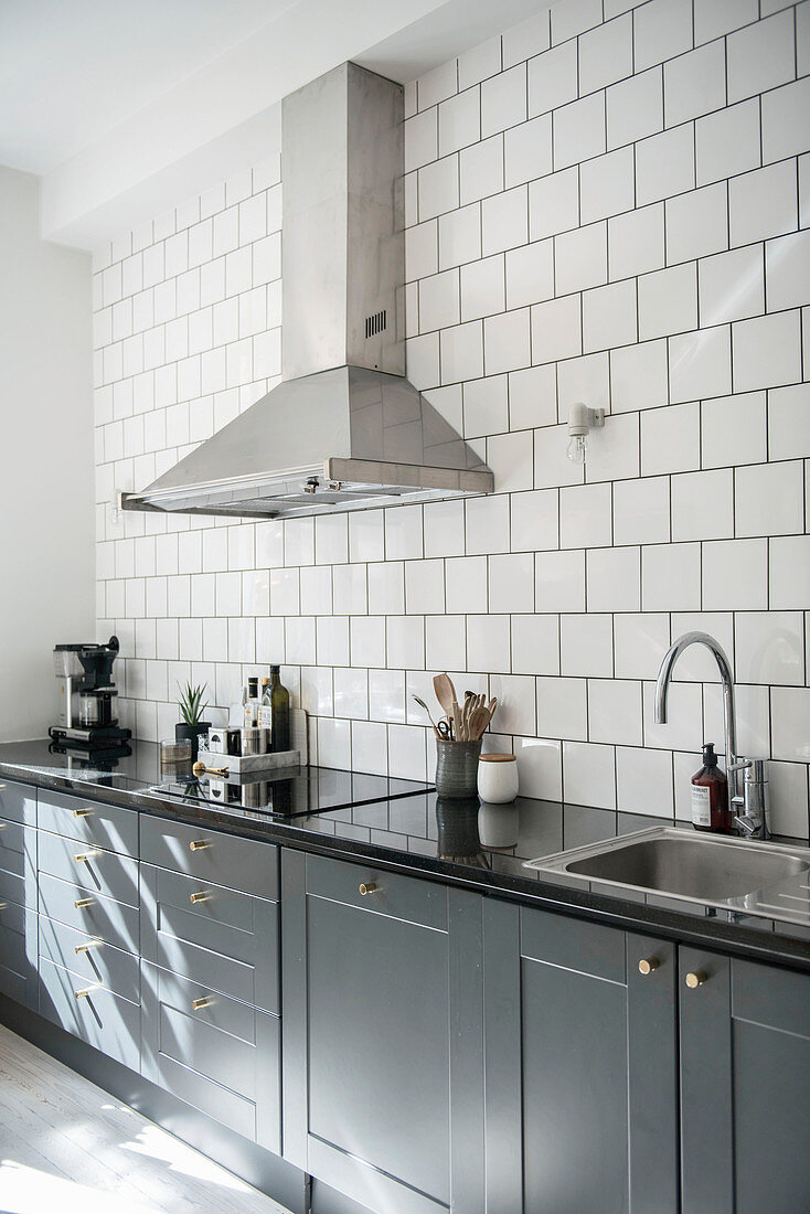 Extractor hood above classic kitchen unit with grey cupboards