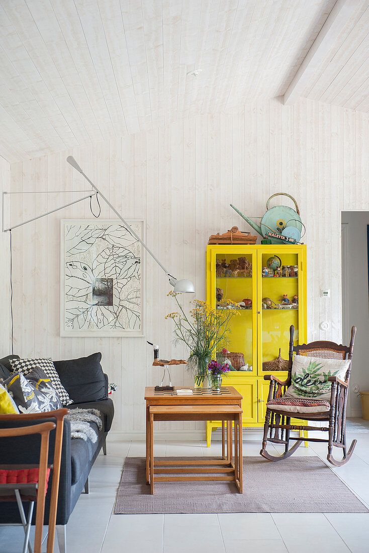 Yellow display case and old rocking chair in living room