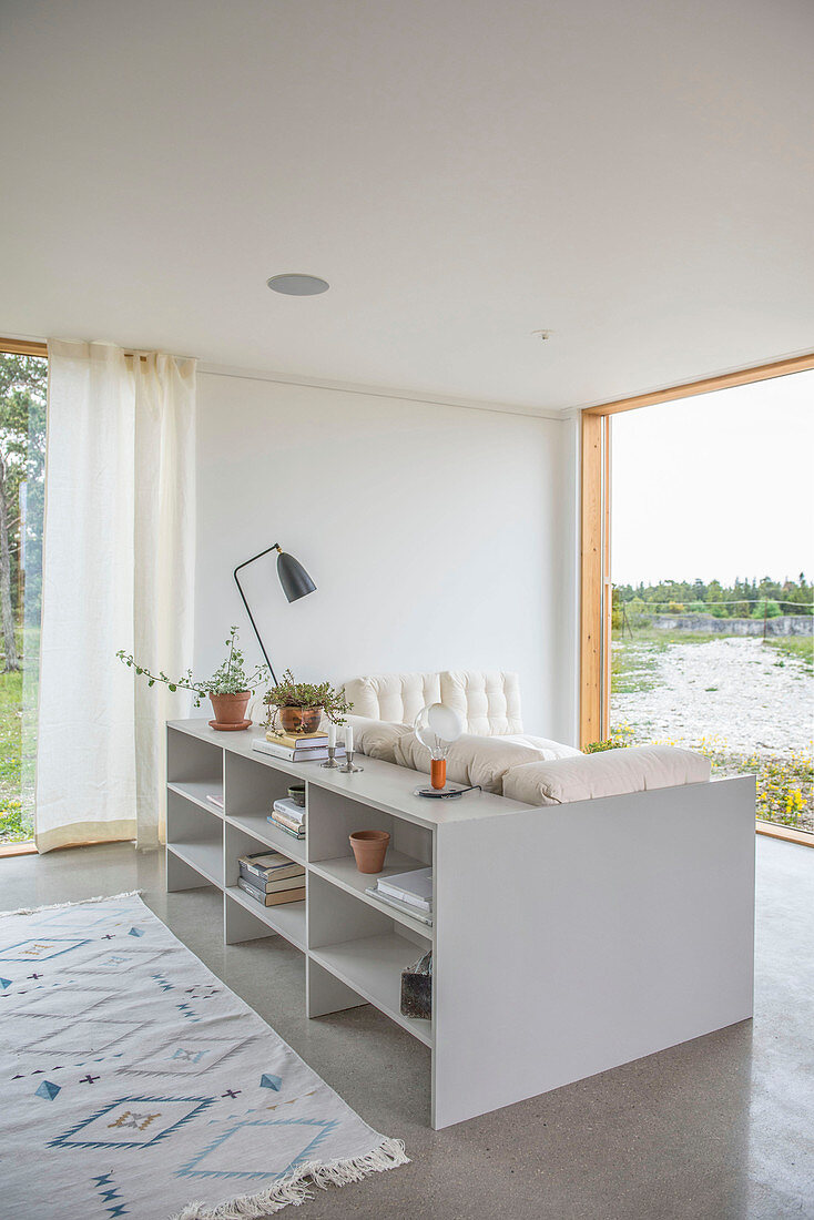 Shelves used as partition behind sofa in front of panoramic window