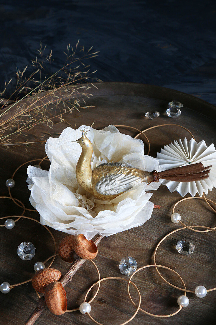 Original arrangement on Christmas table with antique golden peacock on wooden tray