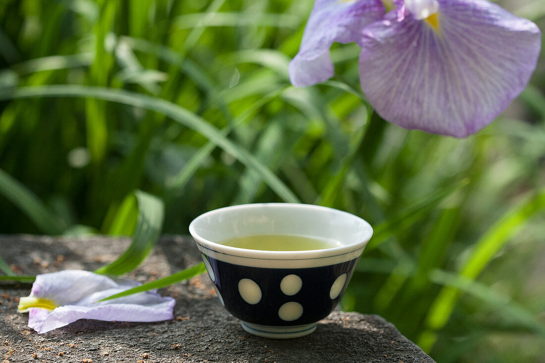 Grüner Tee im Schälchen und japanische Sumpfiris