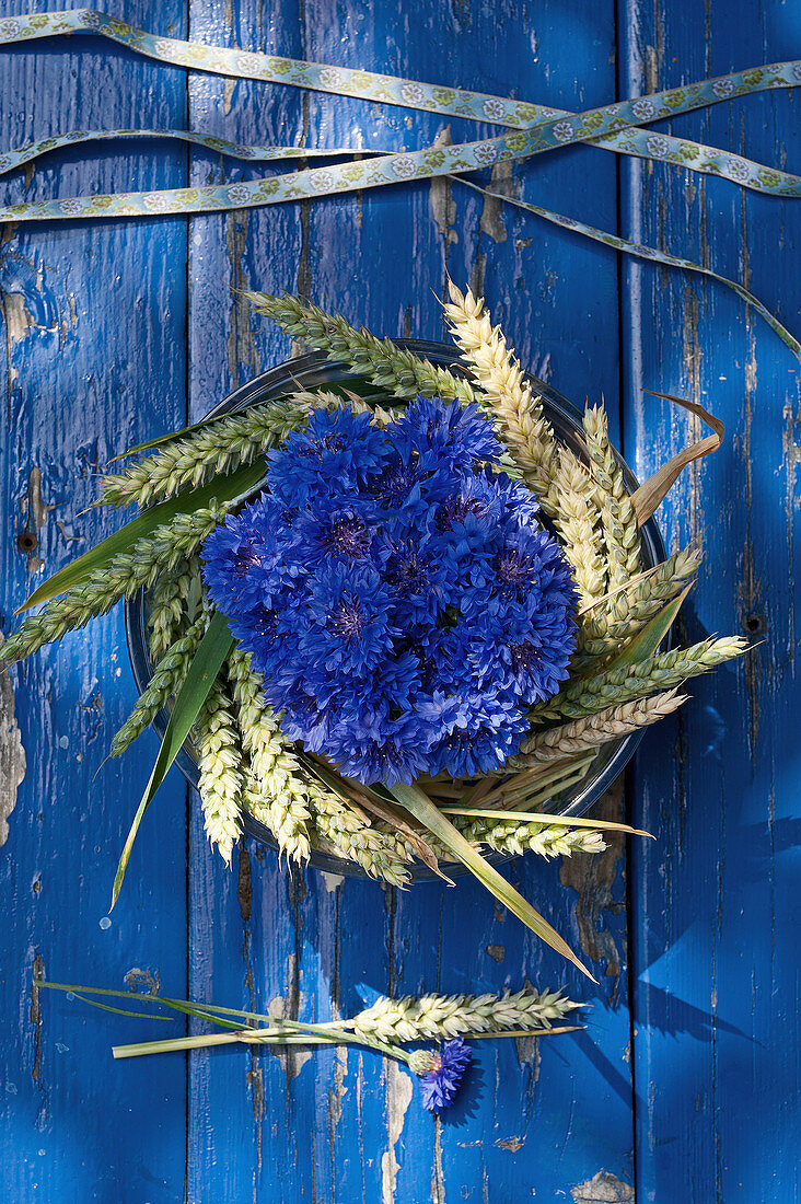 Arrangement of cornflowers in a wreath of wheat ears