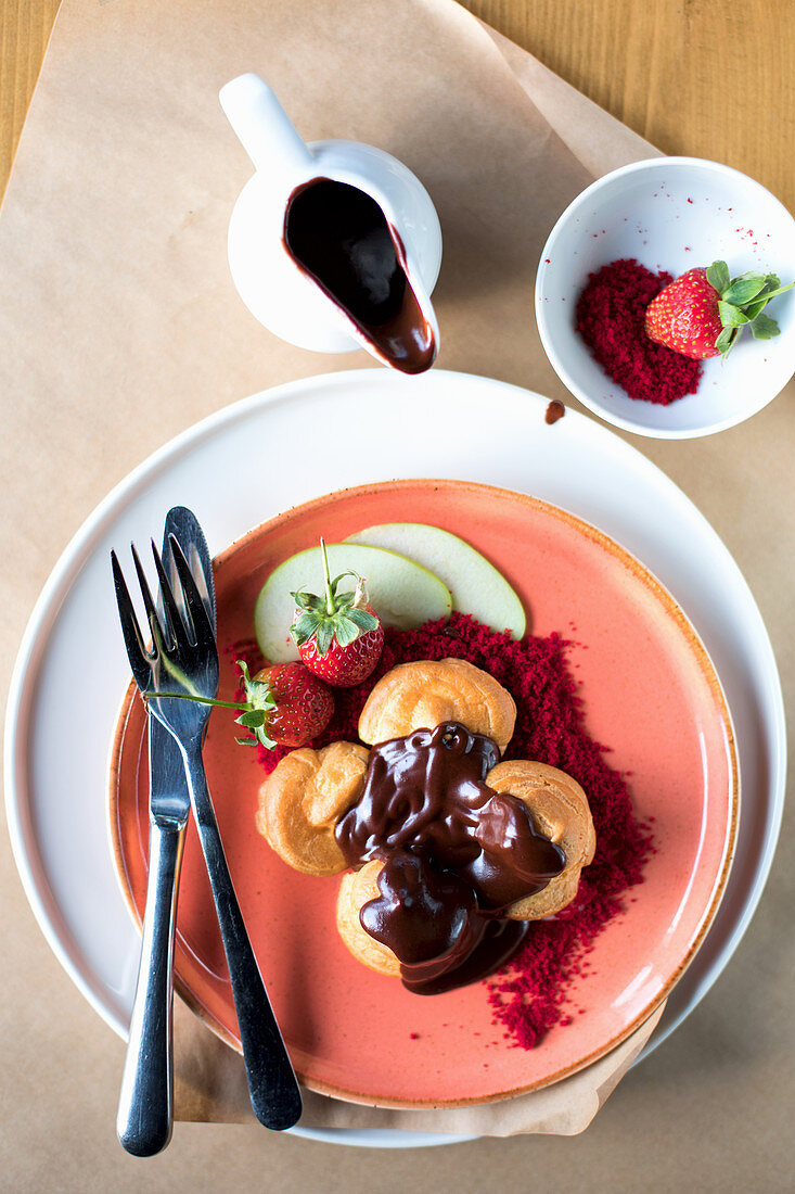 Profiteroles mit geschmolzener Schokolade und Früchten