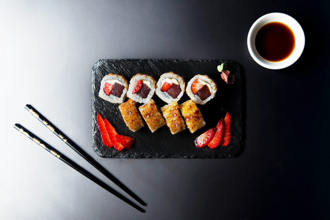 Sushi roll with tuna, strawberry and cream cheese, brown crystal caramel on the top