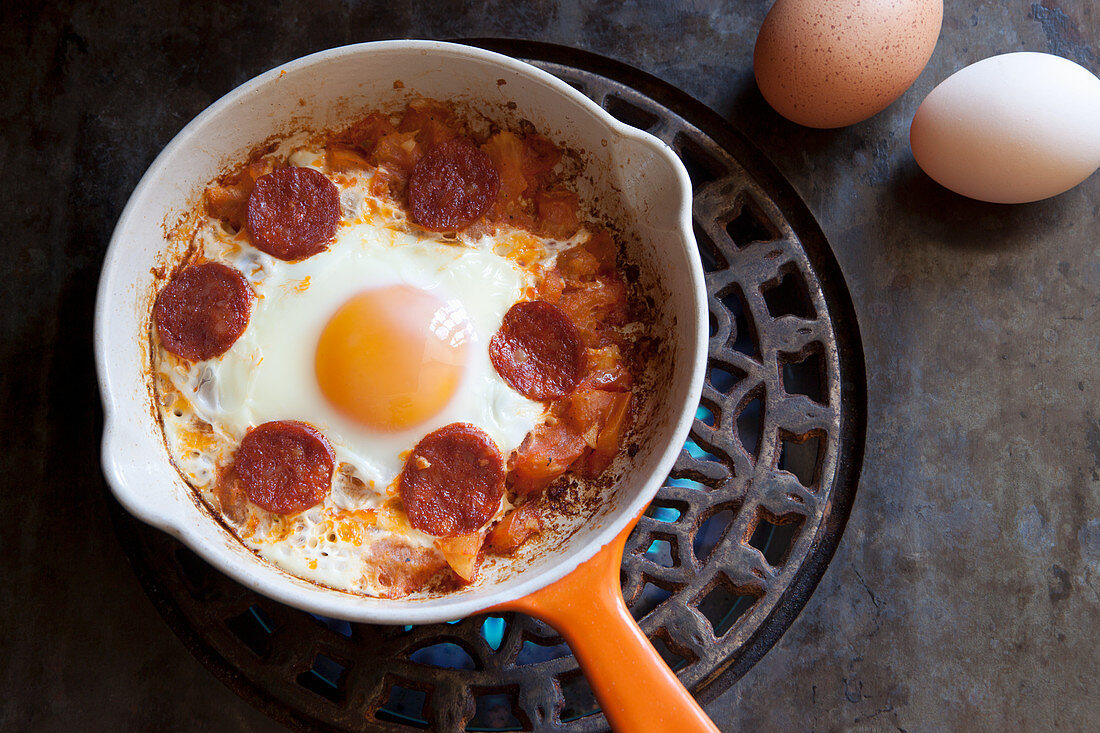 Spanish style breakfast with tomatoes, chorizo and fried egg