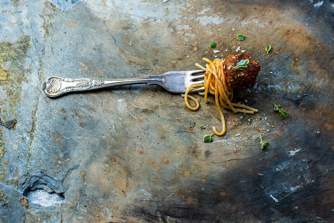 Spaghetti mit Fleischbällchen aufgespießt auf einer Gabel