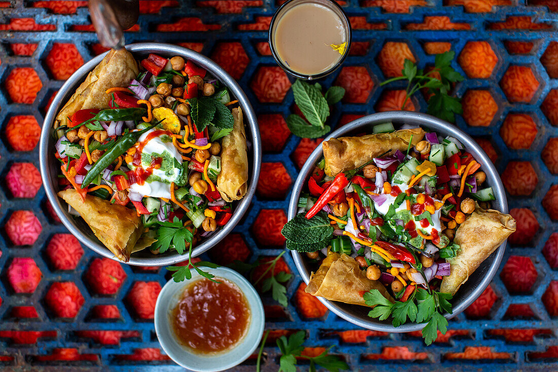 Chaat salad (spicy chickpea salad, India) with samosas and peanuts
