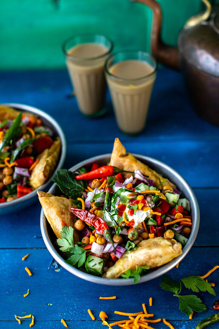 Chaat salad (spicy chickpea salad, India) with samosas and peanuts