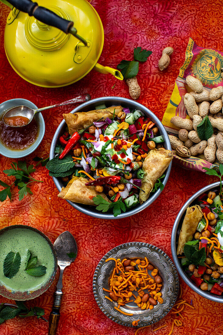 Chaat-Salat (scharfer Kichererbsensalat, Indien) mit Samosas und Erdnüssen