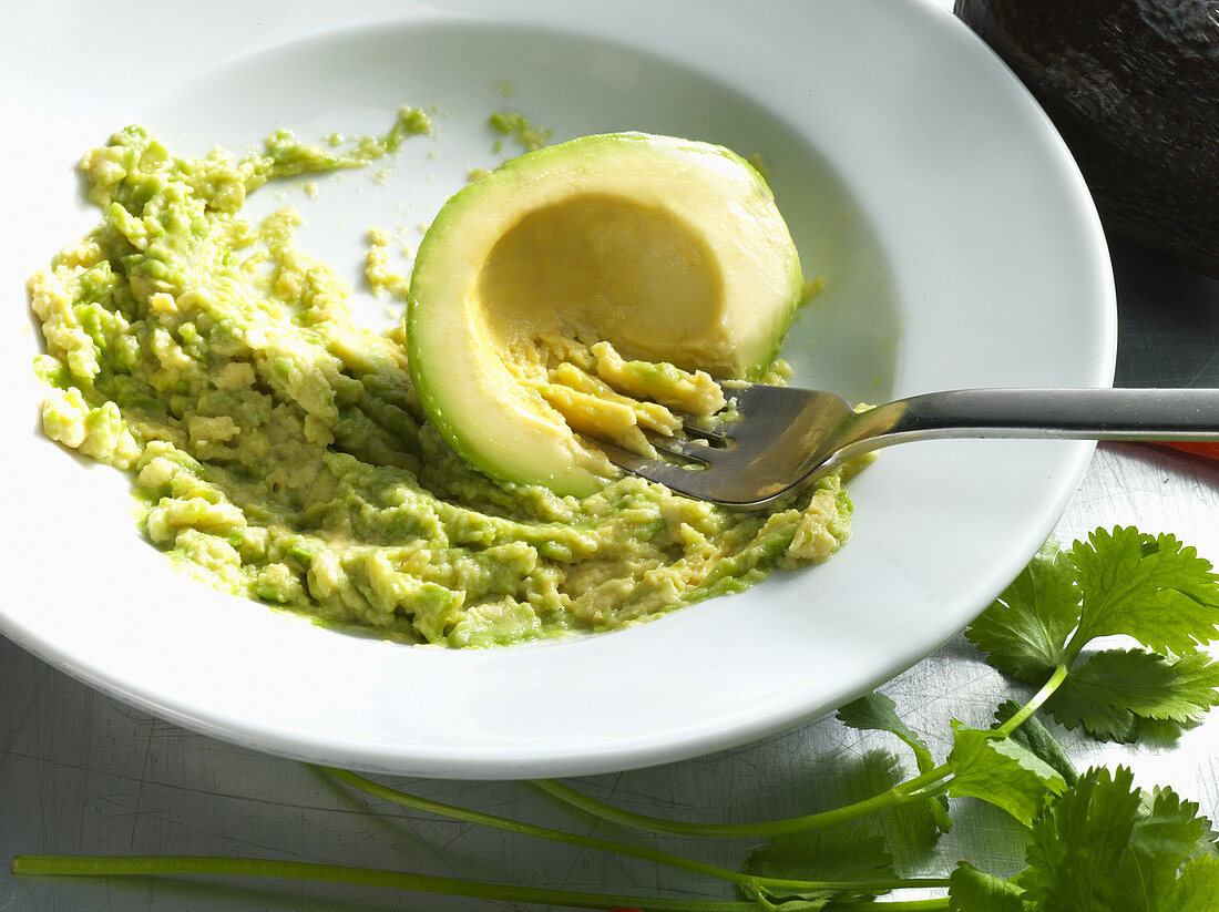 An avocado being mashed