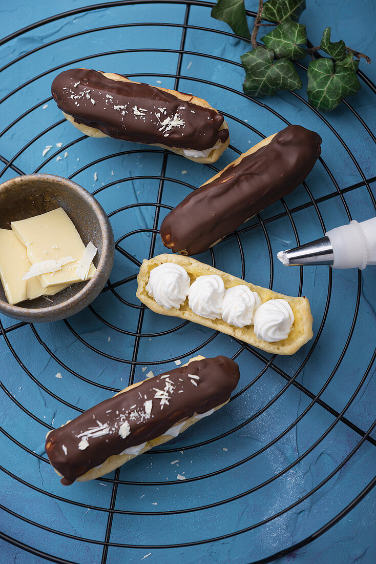 Chocolate eclairs being filled with whipped soya cream