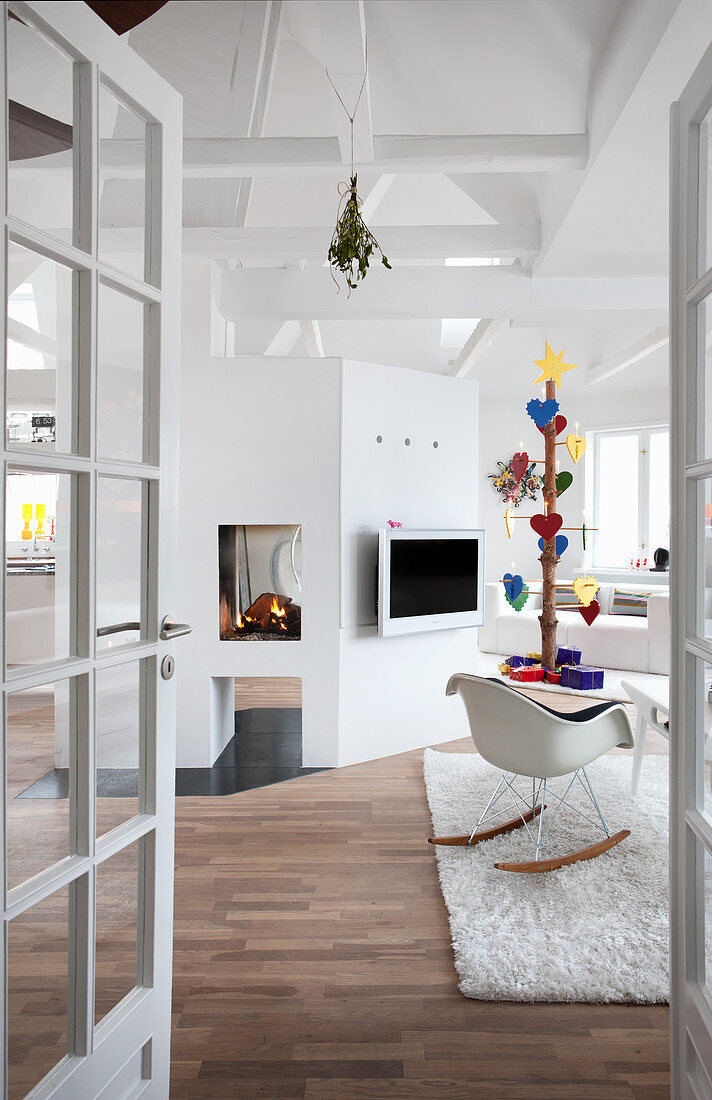 View into white living room with exposed ceiling structure and open fire
