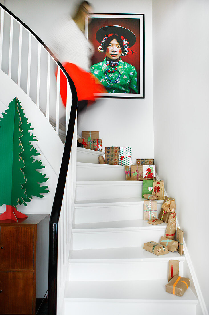 Verpackte Geschenke auf weißer Treppe mit Weihnachtsdeko