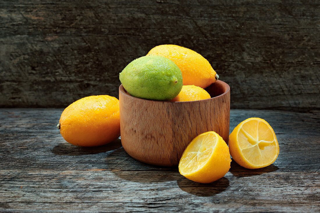 Limequats in Holzschale und daneben