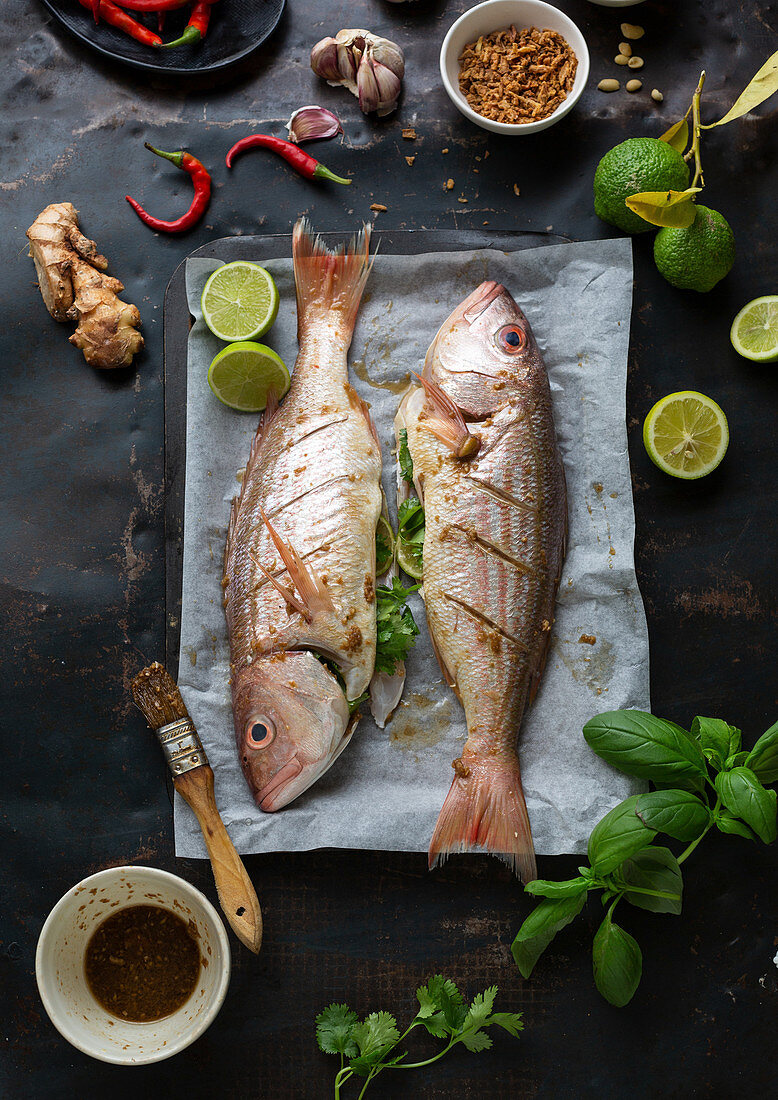 Rohe Fische mit Zutaten auf Ofenblech