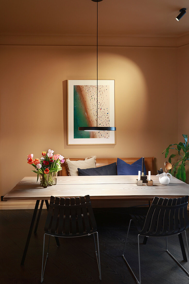 Modern pendant lamp above dining table against beige wall