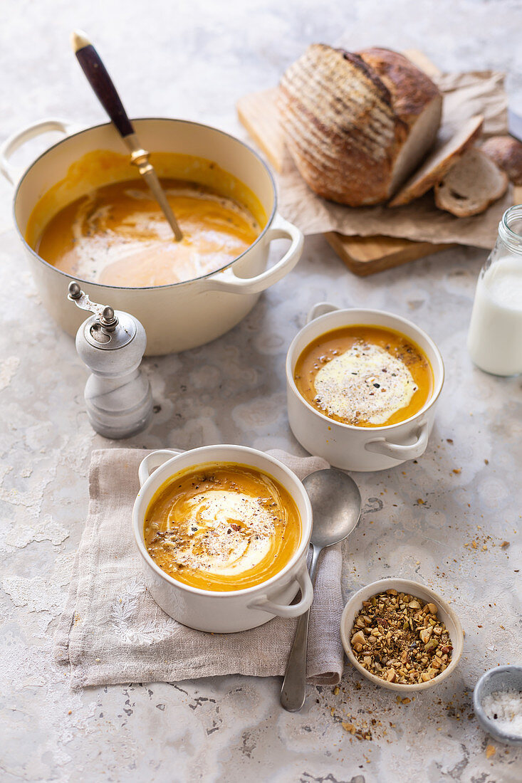 Butternusskürbissuppe im Topf und in Suppenschälchen