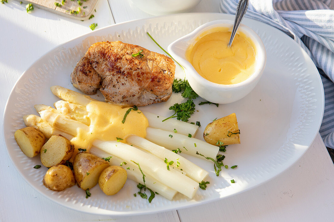 Pork steak with white asparagus and sauce Hollandaise