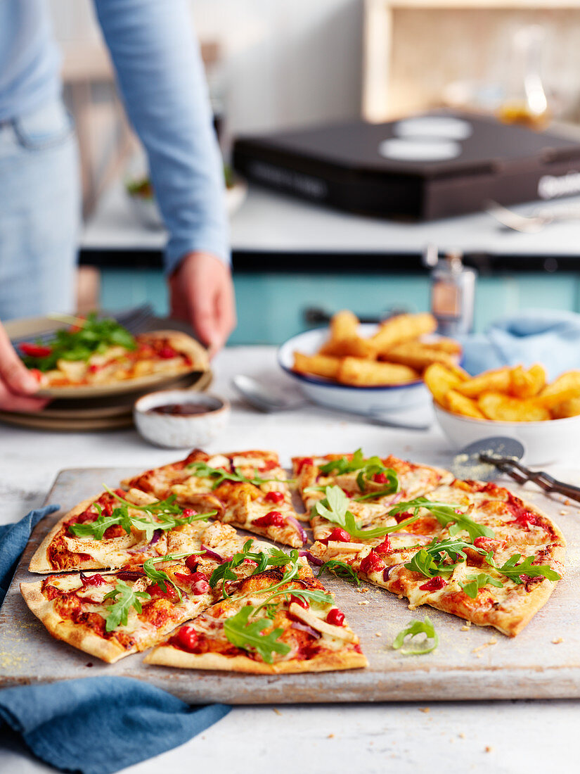 Pizza mit Rucola auf Holzbrett