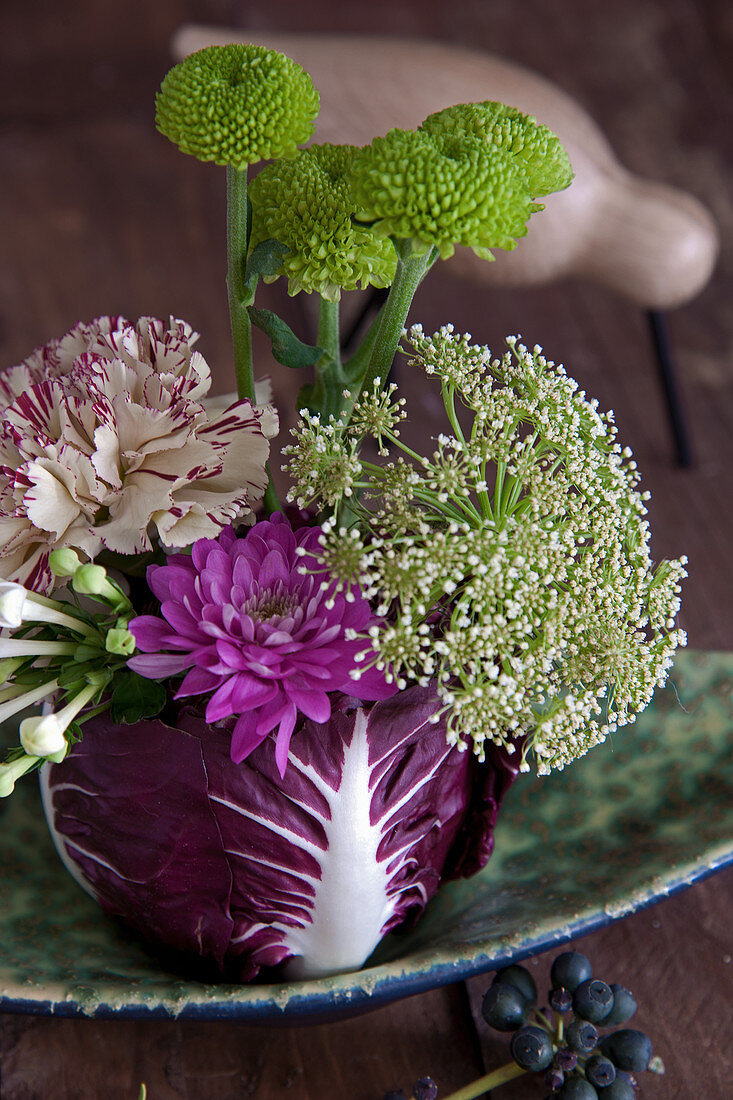 Gesteck aus Knorpelmöhre, Chrysanthemen, Nelke und Bouvardie in Radicchio