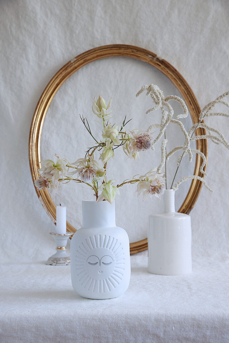 Weiße Vasen mit künstlichen Blumen
