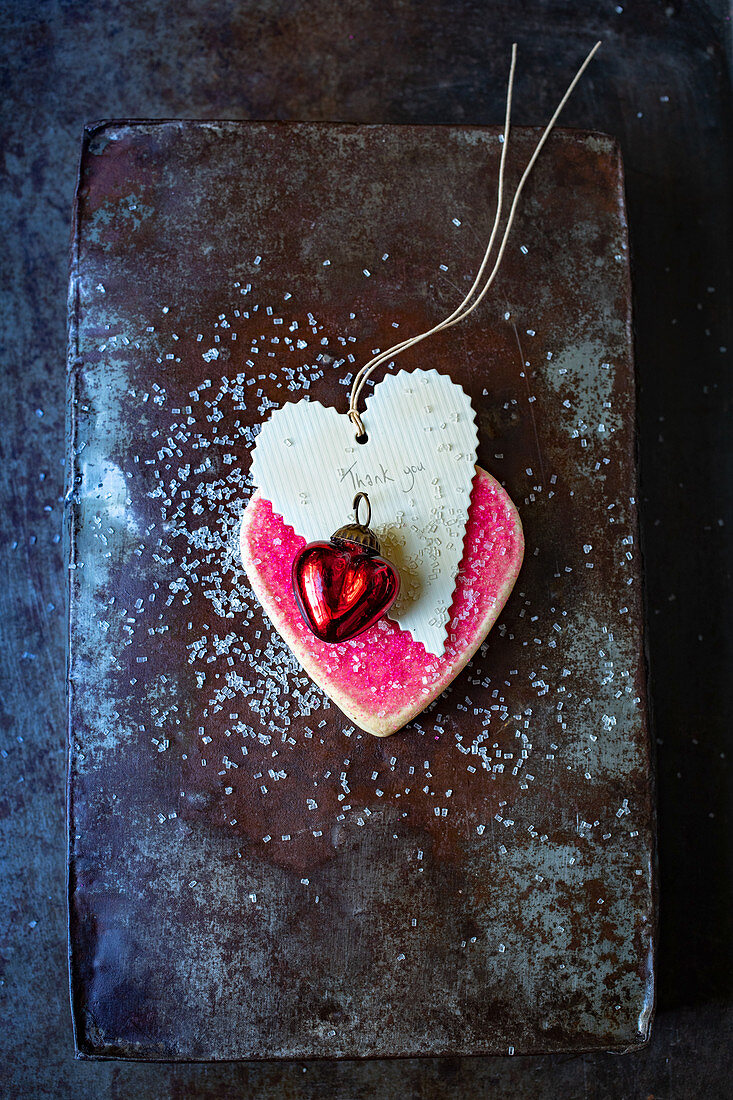 A pink heart-shaped biscuits with a pendant
