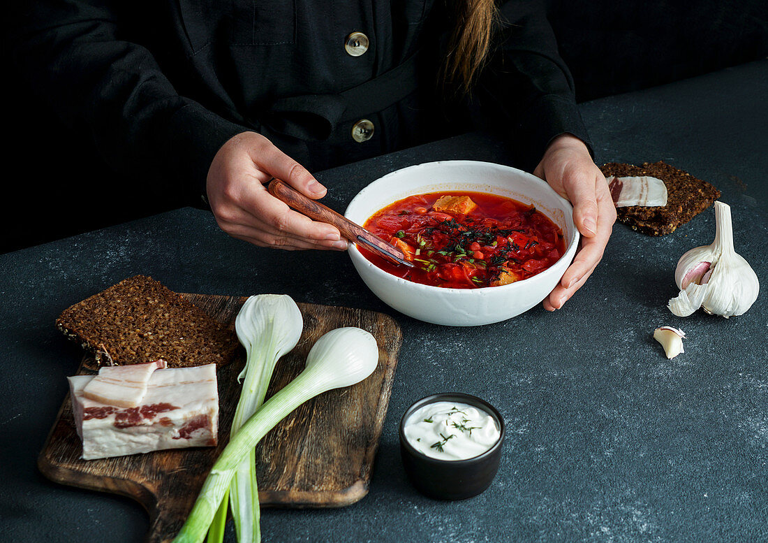 Borsch (Red beetroot soup) with girls hands, russian and ucranian food