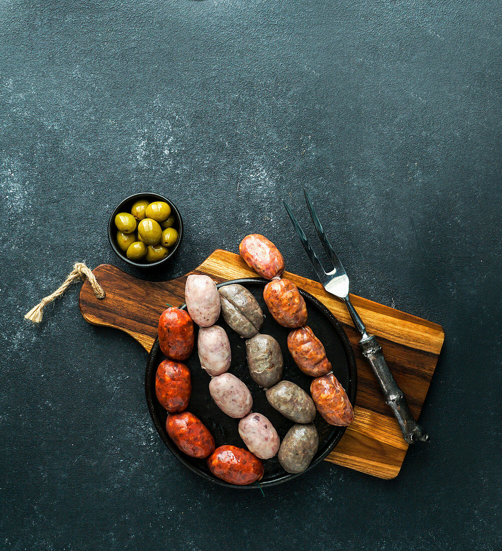 Spanish sausages on the cutting board (butifarra blanca, chorizo, morcilla de cebolla)