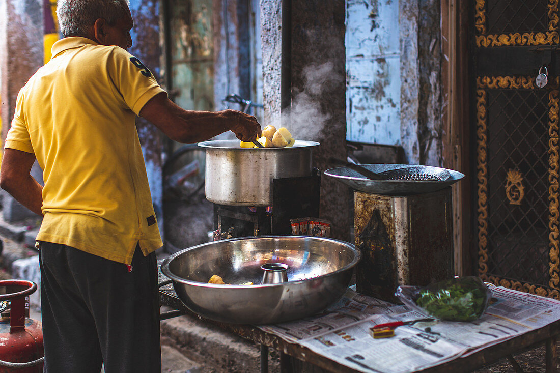 Mann bereitet Currygericht in Strassenküche zu (Jodhpur, Indien)