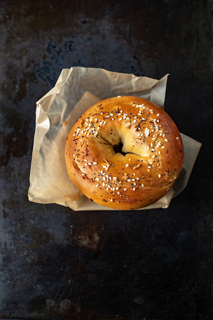 A sesame seed bagel on a piece of paper