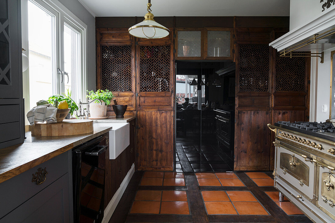 Rustikale Landhausküche mit dunklen Holzfronten und Speisekammer
