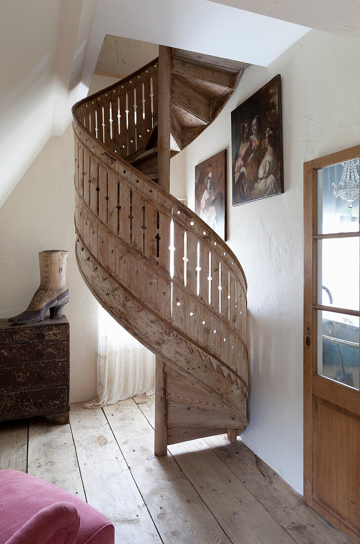 Shabby-chic spiral staircase on rustic wooden floor
