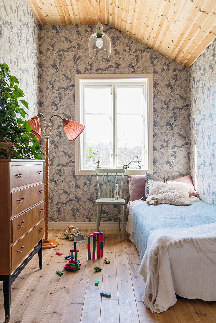 Kleines Kinderzimmer mit blauer Vintagetapete und Holzboden