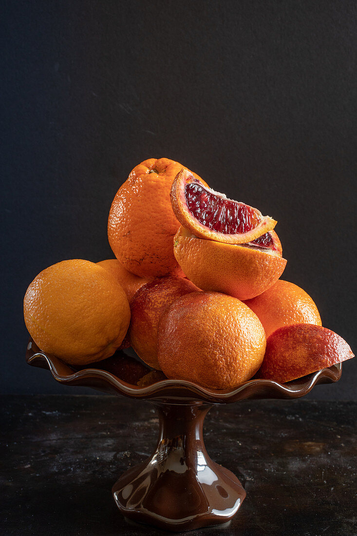 Orangen und Blutorangen in Keramikschale