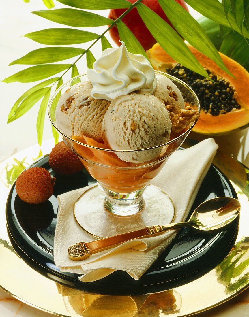 Three scoops of walnut ice cream with cream on papayas 