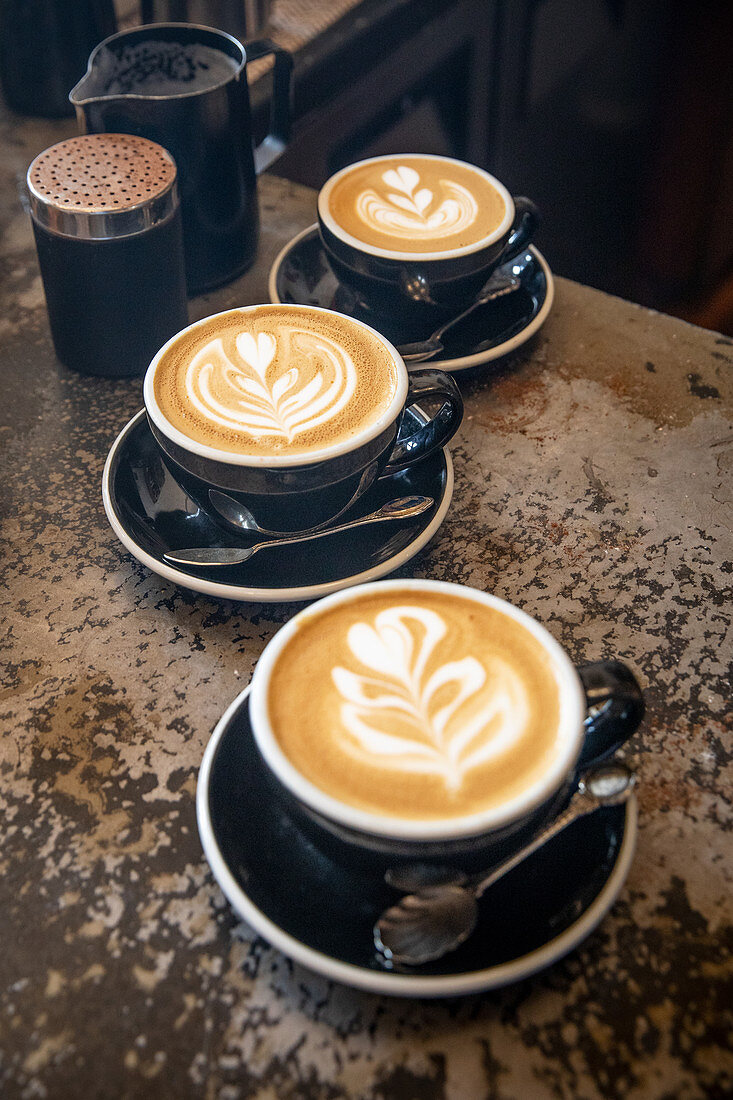 Cappuccinos with milk foam patterns (latte art)