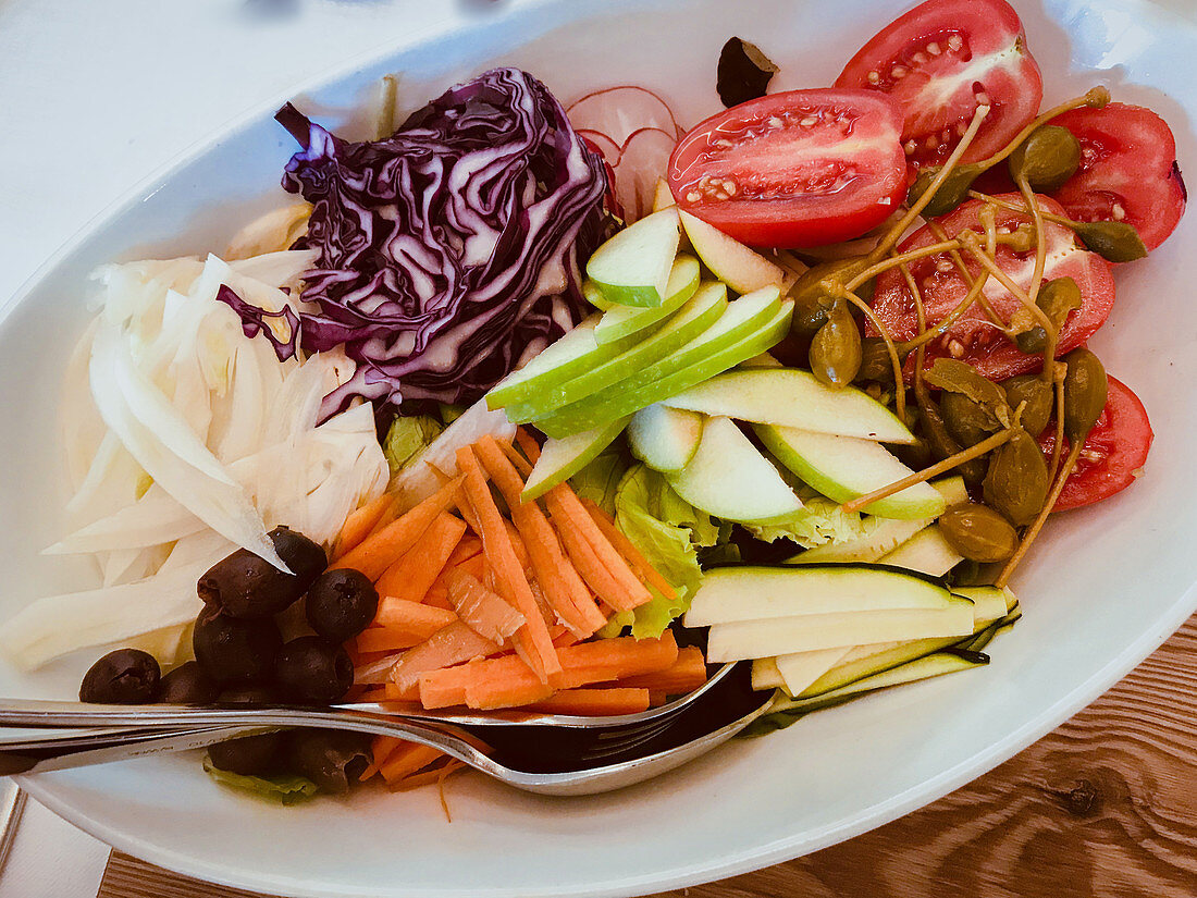 A mixed vegetables salad with apples and capers (Italy)