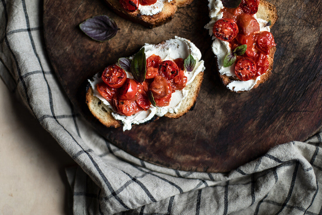 Grilled bread topped with cream cheese, cherry tomatoes and rhubarb
