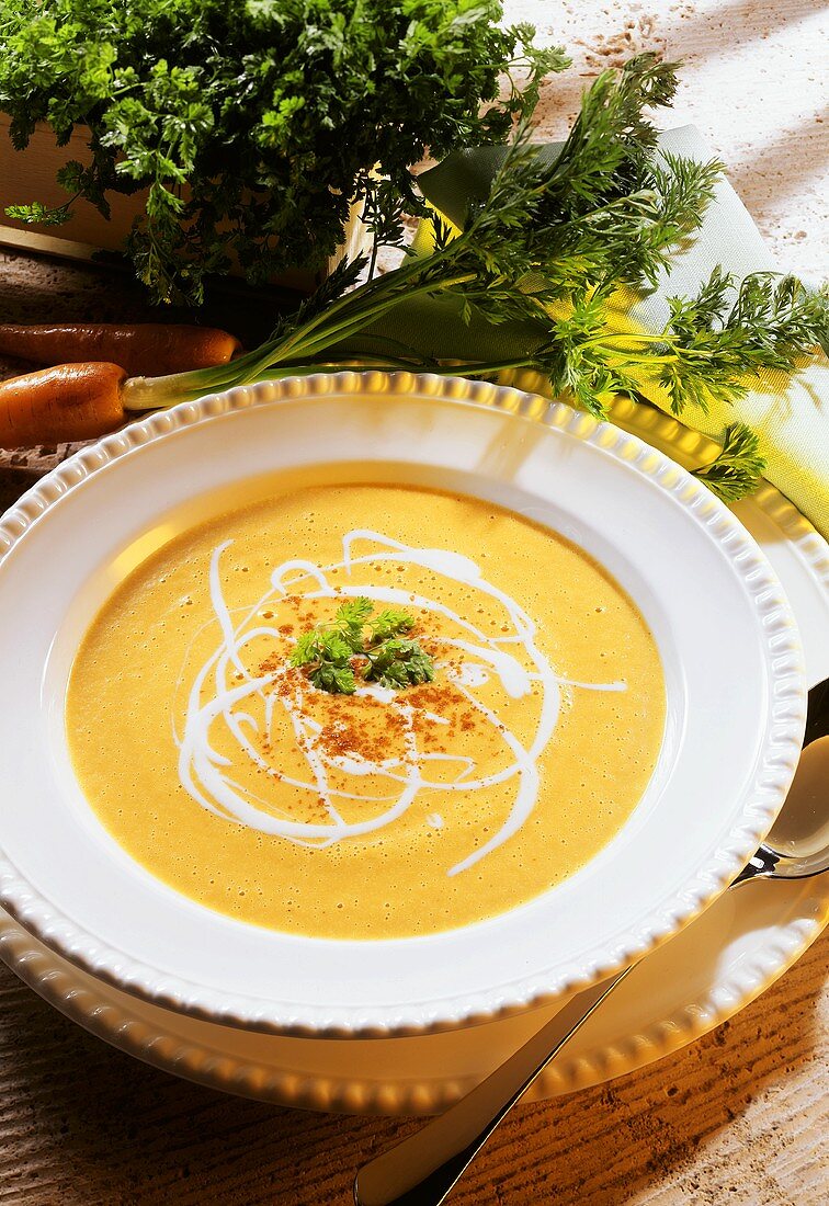 Carrot soup with sour cream & cayenne pepper in plate