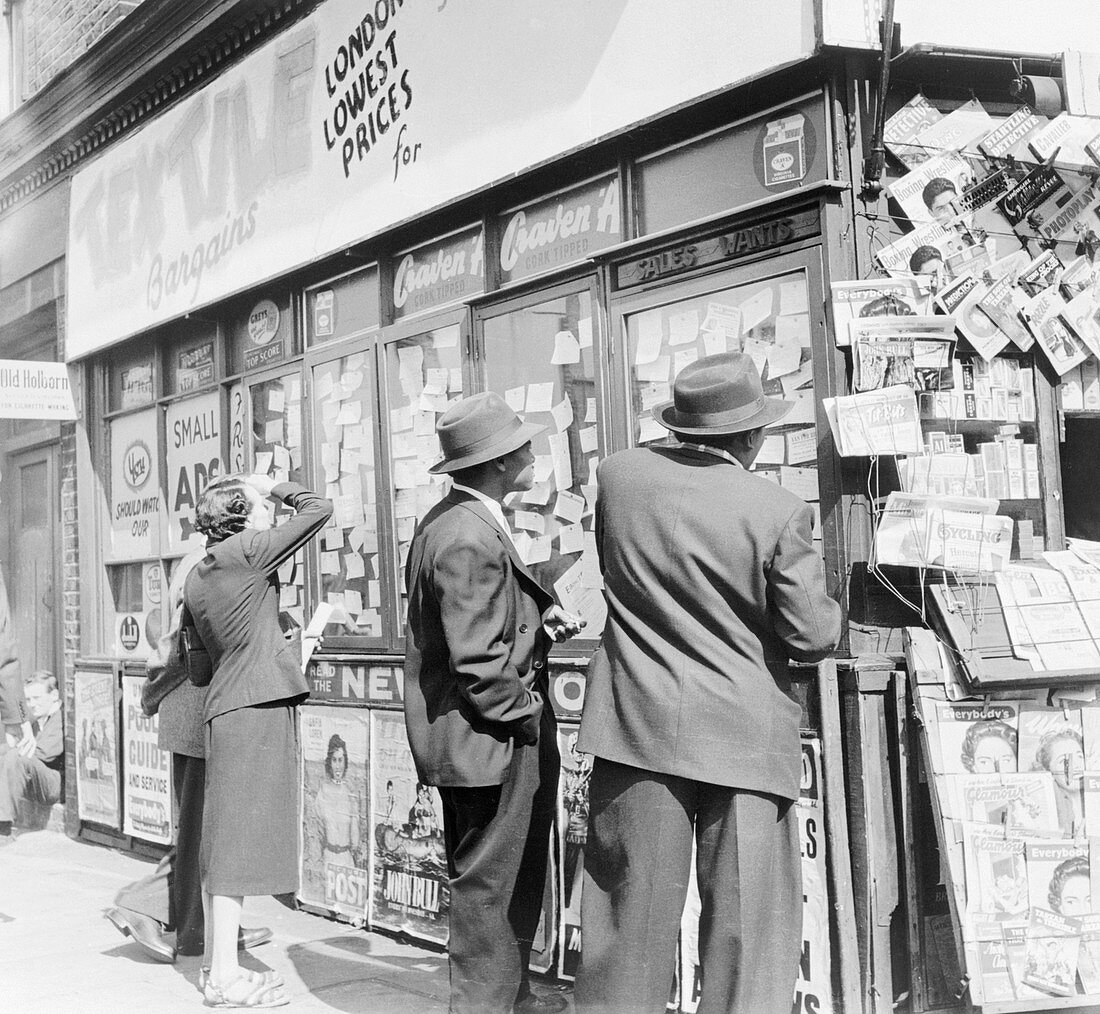 Advertisements in a newsagents window, c1955