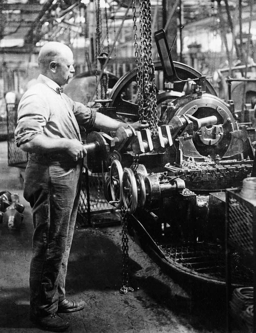 Man operating machinery in a car factory