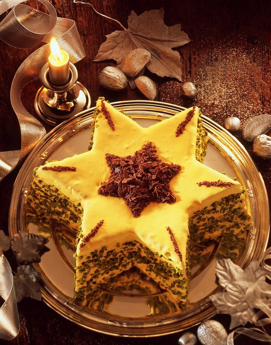 Star-shaped cake with icing, chocolate sprinkles & pistachios
