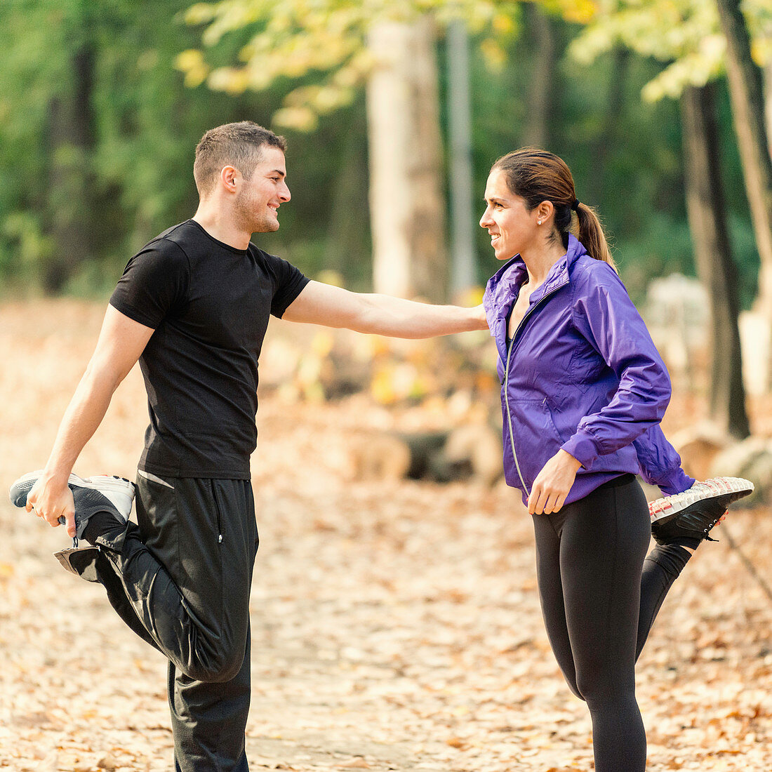 Happy couple exercising in park