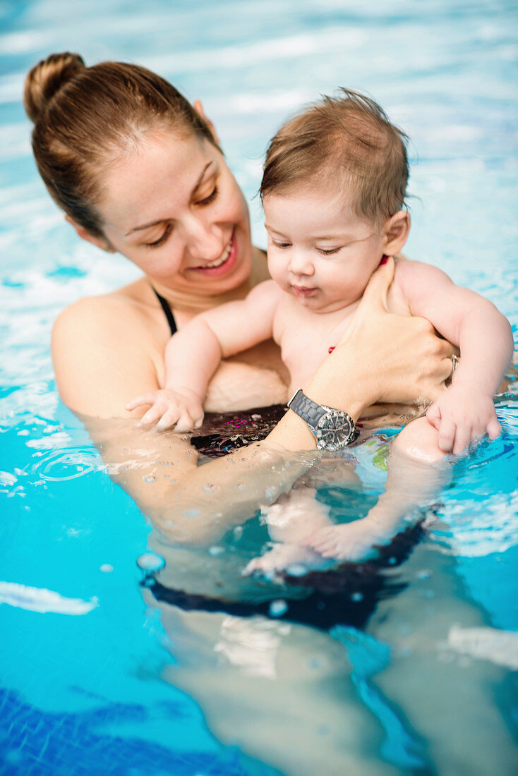 Baby boy with mother in swimming pool