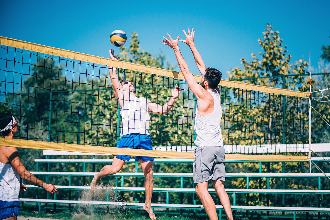 Beach volleyball players at the net