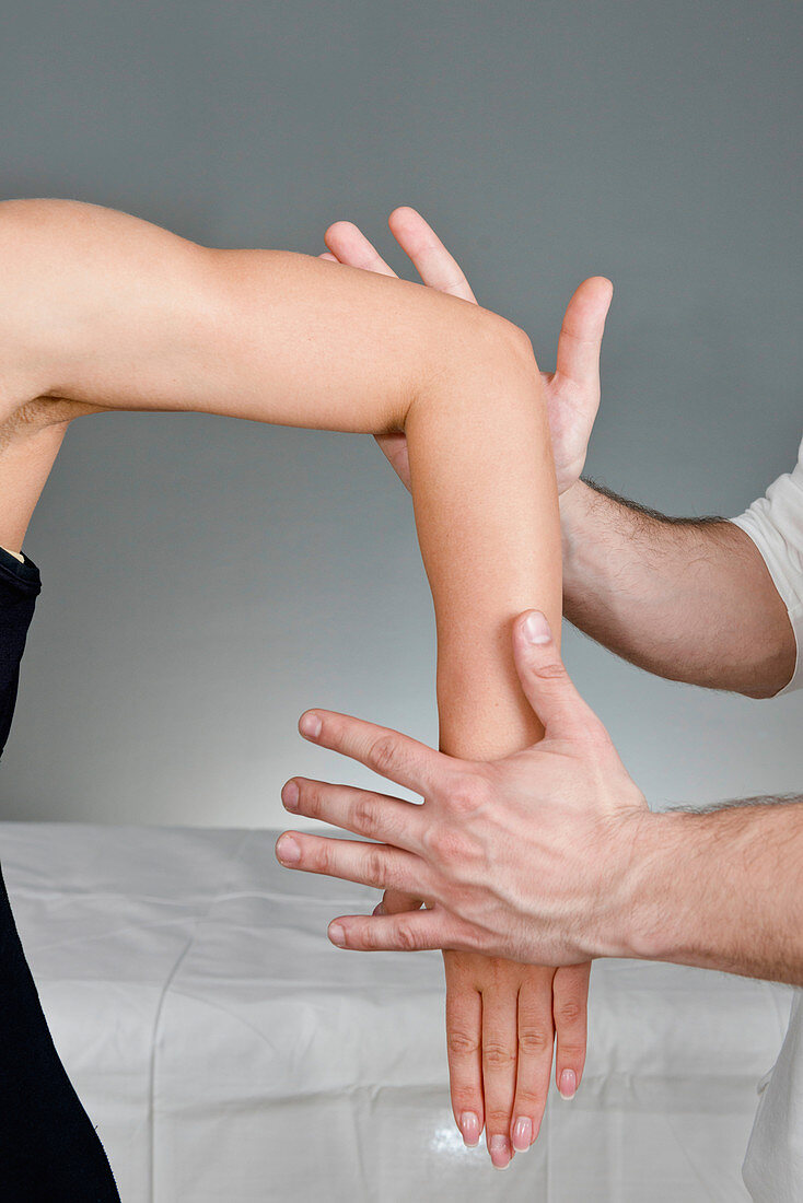 Chiropractor examining patient's arm